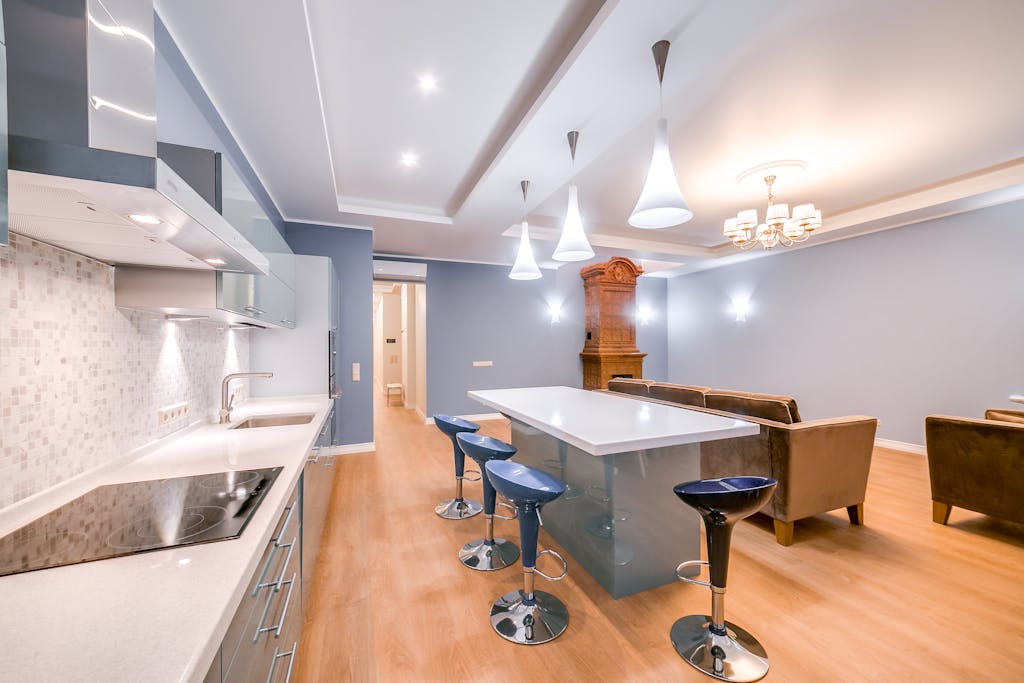 Spacious modern kitchen with living room, featuring minimalist design and luxury furniture.